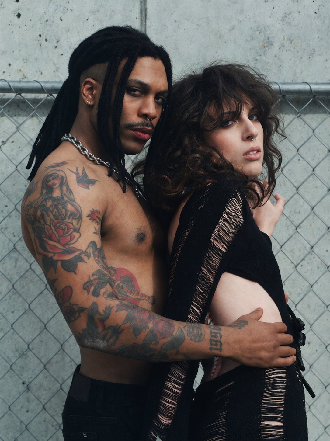 Couple against a chain-link fence