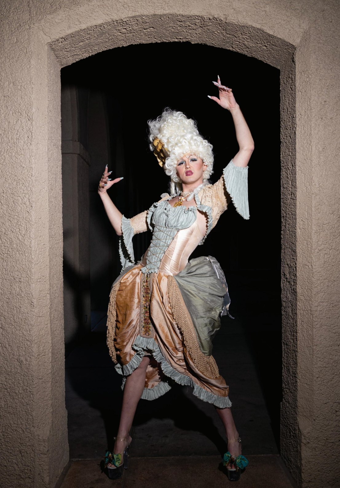 Framed in a dark stucco archway at night