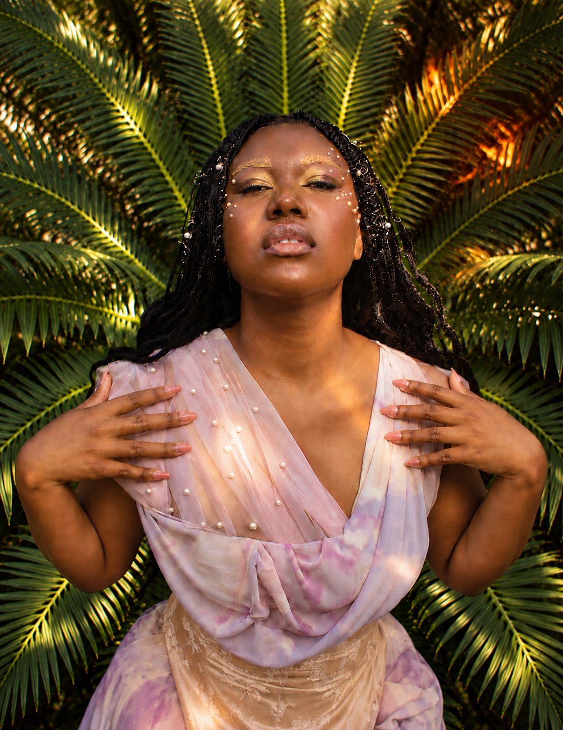 Portrait with gold brows and pearls against palm fronds