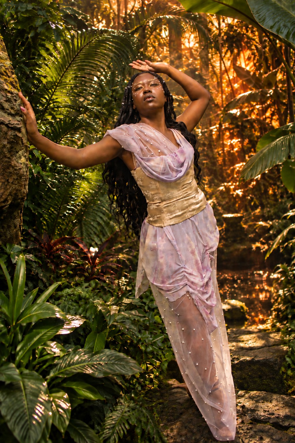 A figure in a pearl-studded pale pink gown standing in lit foliage, Strike Magazine editorial