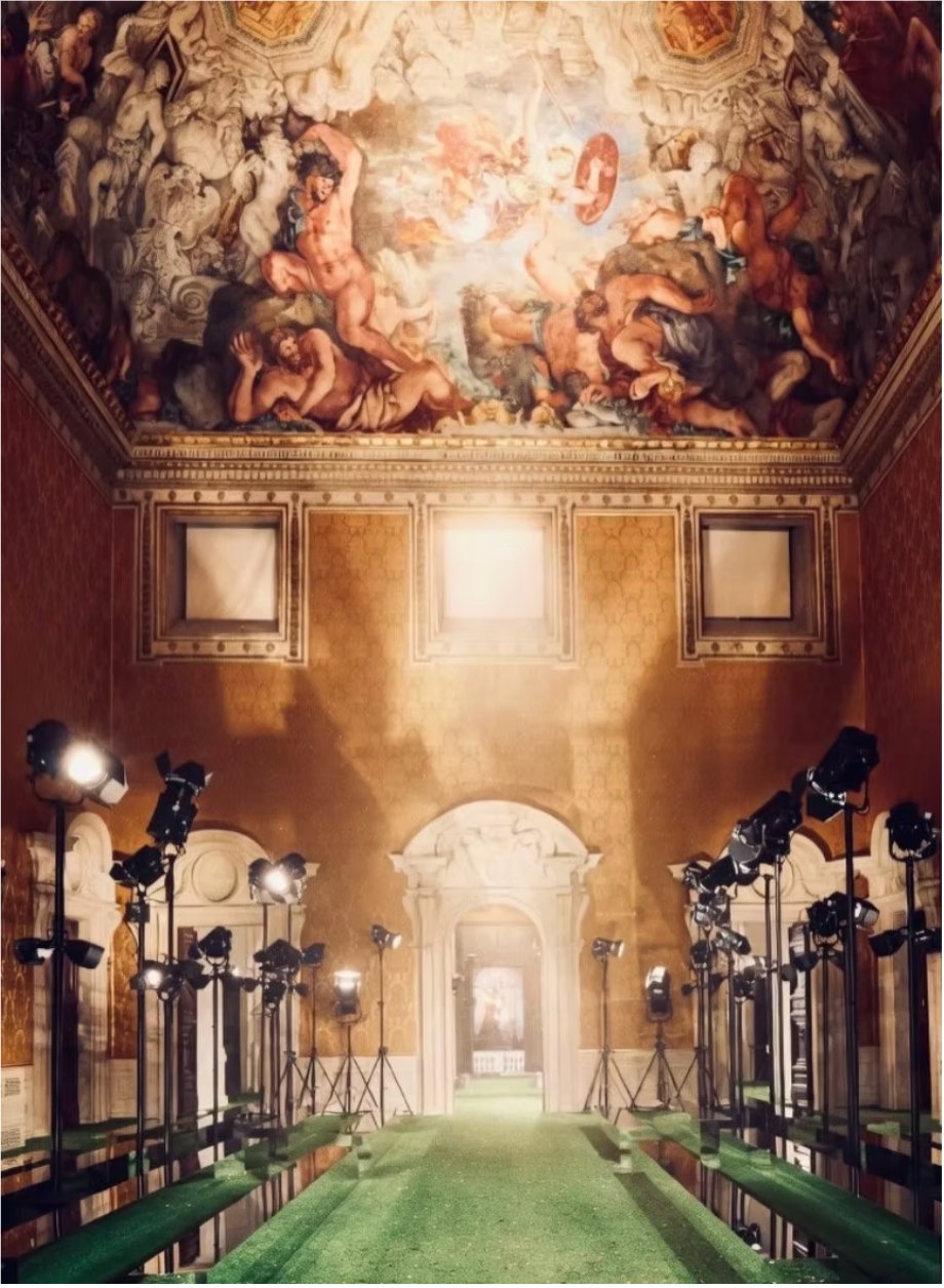 A frescoed baroque hall at the Palazzo Barberini lined with film lights above a green runway