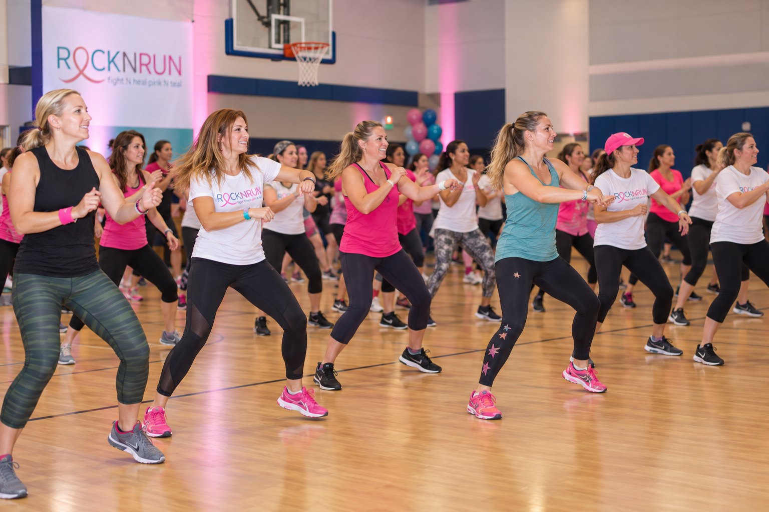 A gym full of participants in Rock N Run shirts following a dance class together