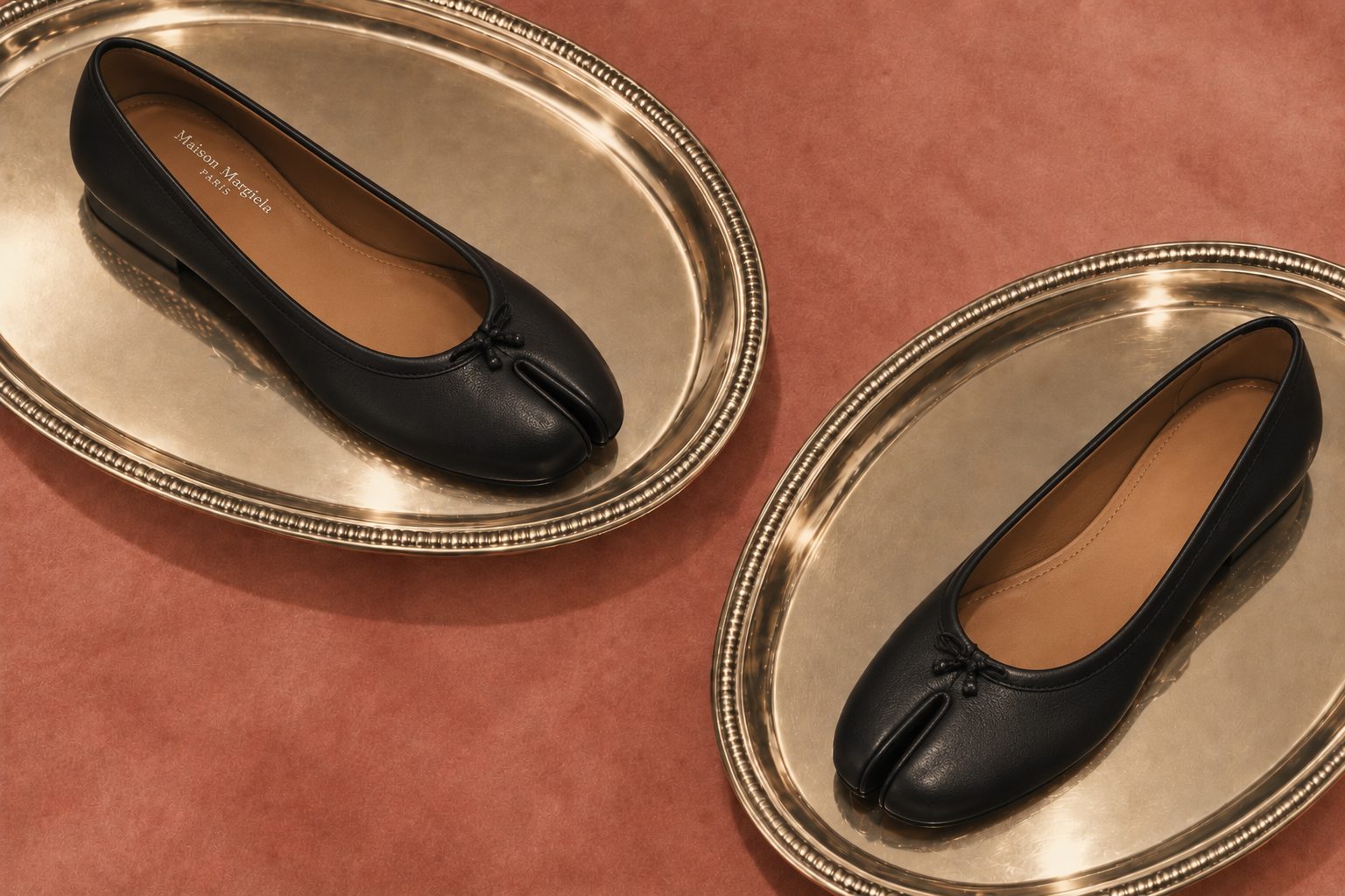 Two black split-toe flats on gold platters